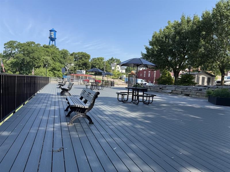 Accessible riverside gathering space at Island Park with benches and picnic tables